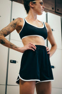 Short The All Black noir à taille haute et bordures claires, porté debout de face