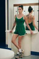 Body Tennis Club vert porté debout avec un short, avec le dos visible dans le miroir.