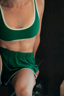 Vue rapprochée de la brassière Tennis Club verte et de son encolure arrondie bordée de crème